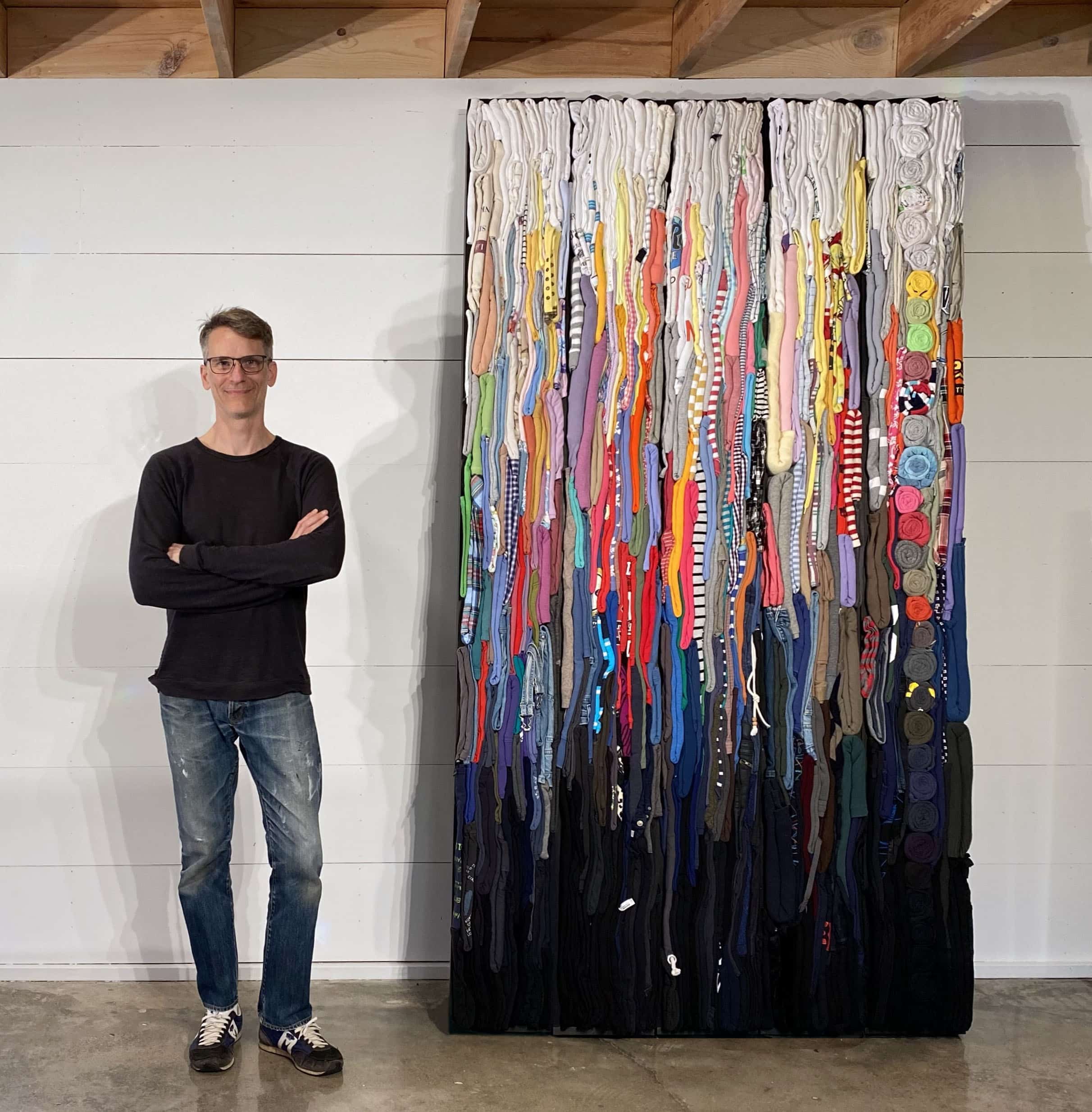 Derick Melander standing in front of his piece The Witness